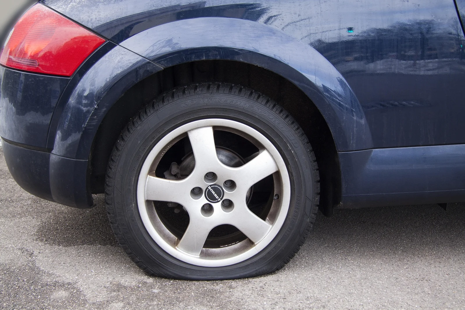 Pneu crevé sur une voiture à l’arrêt, cause fréquente de panne